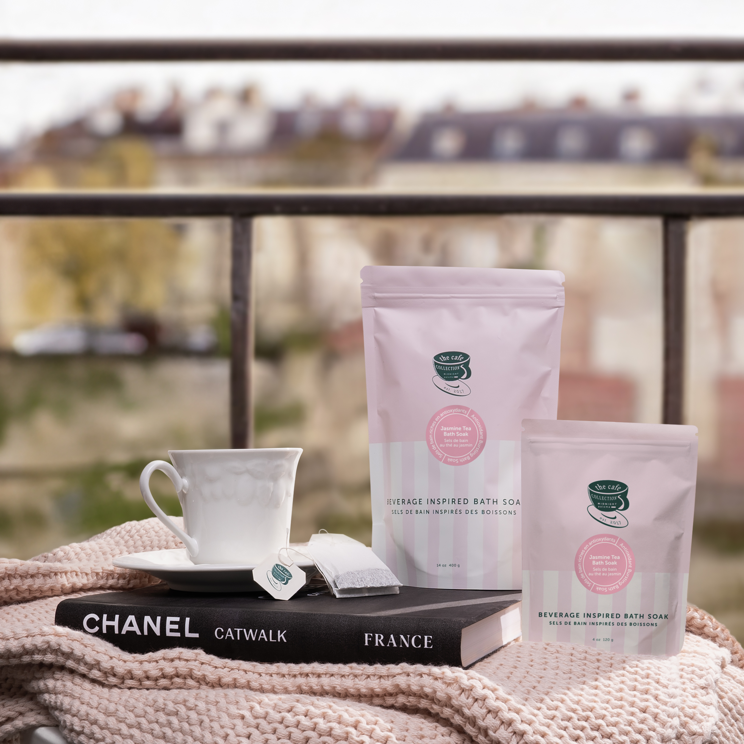 Danielle Gracioso Graphic Designer Vancouver BC Canada – Jasmine Tea Bath Soak pouches styled with a tea cup, Chanel book, and soft knit blanket on a balcony. Photography and art direction by Danielle Gracioso.